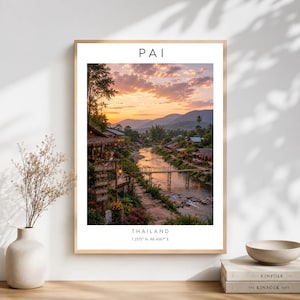 Puede incluir: Una lámina de arte mural enmarcada que muestra un paisaje al atardecer de Pai, Tailandia, con un río, un puente y montañas. El texto PAI aparece en la parte superior y THAILAND 7.2575 N, 98.4367 E está impreso en la parte inferior del póster.