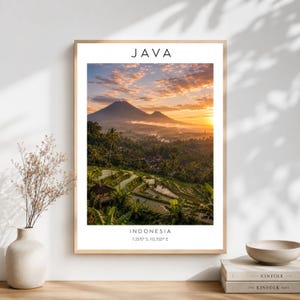 May include: A vertical wall art print featuring a landscape of Java, Indonesia, with rice terraces in the foreground and mountains under a golden sunrise sky. The text JAVA appears at the top, with INDONESIA and 7.2575 S, 112.7521 E at the bottom.