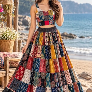 May include: A two-piece outfit consisting of a sleeveless crop top and a long, full-length skirt. Both pieces feature a vibrant, multi-colored patchwork design with various floral and geometric patterns in shades of red, blue, yellow, and white.