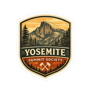May include: A shield-shaped sticker featuring a mountain landscape in shades of orange, black, and cream. The text YOSEMITE SUMMIT SOCIETY is printed in the center, with an illustration of two crossed climbing axes below the text.