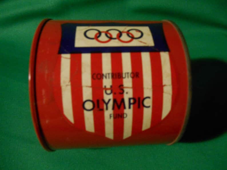 1 Circa 1960/'s. One US Olympic Fund Bank Pressed Steel