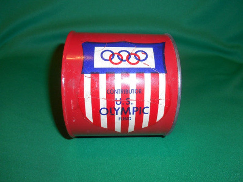 1 Circa 1960/'s. One US Olympic Fund Bank Pressed Steel