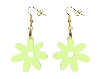 May include: A pair of light green daisy-shaped earrings with gold-colored hooks and hoops. The earrings have a simple, minimalist design, perfect for adding a touch of spring to any outfit. The earrings are set against a white background.