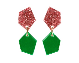 May include: A pair of dangle earrings with a geometric shape. The top part of the earrings is a sparkly pink, and the bottom part is a solid green.