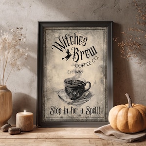 May include: A framed wall art print featuring a vintage-style graphic with the text Witches Brew Coffee Co. Est. 1498 and Stop in for a Spell. The design includes a black coffee cup on a saucer with a spoon, set against a textured background.