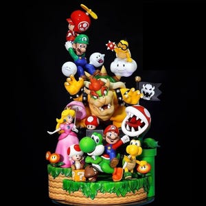 Può includere: Un set di statuette a tema Super Mario con Mario, Luigi, la Principessa Peach, Bowser, Yoshi, Toad e una Pianta Piranha. La composizione colorata include vari elementi iconici del gioco come un tubo verde, un blocco e una bandiera.