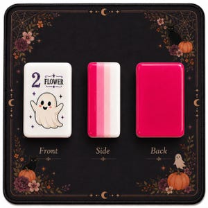 May include: Three rectangular mahjong tiles displayed on a black mat with floral and ghost motifs. The left tile is white with a ghost illustration and the text 2 FLOWER. The middle tile shows pink and white stripes. The right tile is solid pink.