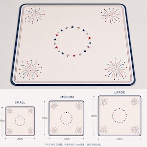 Puede incluir: Una alfombrilla cuadrada de color blanco roto con un borde azul oscuro, con ilustraciones de fuegos artificiales rojos y azules en las esquinas y un patr&oacute;n circular central de estrellas rojas y azules. Se muestran tres tama&ntilde;os: 26, 33 y 39 pulgadas.