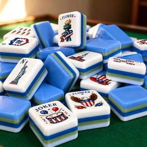 May include: A collection of rectangular mahjong tiles featuring white faces with colorful illustrations of American symbols like the Statue of Liberty, a bald eagle, and a drum, with blue and green layered sides and the text FLOWER and JOKER.