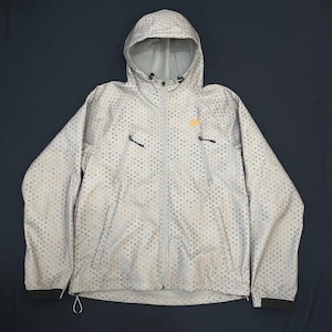 May include: A light gray hooded jacket featuring a repeating geometric pattern of small dark squares. The jacket includes a full-length front zipper, two zippered chest pockets with black pulls, a drawstring hood, and long sleeves with dark cuffs.