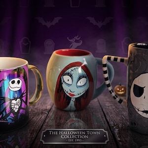 Pode incluir: Tr&ecirc;s canecas de cer&acirc;mica da The Halloween Town Collection Est. 1993. A primeira tem um design roxo e preto com um esqueleto. A segunda &eacute; uma caneca redonda azul-clara com uma personagem feminina. A terceira &eacute; uma caneca alta cinza com um rosto de esqueleto grande e uma al&ccedil;a listrada em preto e branco.