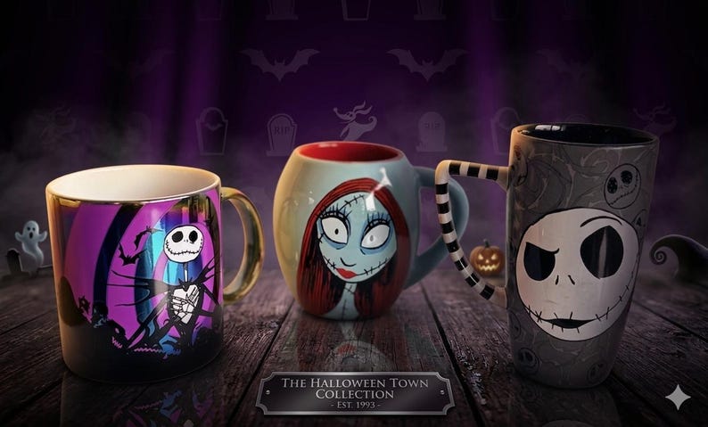 Pode incluir: Tr&ecirc;s canecas de cer&acirc;mica da The Halloween Town Collection Est. 1993. A primeira tem um design roxo e preto com um esqueleto. A segunda &eacute; uma caneca redonda azul-clara com uma personagem feminina. A terceira &eacute; uma caneca alta cinza com um rosto de esqueleto grande e uma al&ccedil;a listrada em preto e branco.