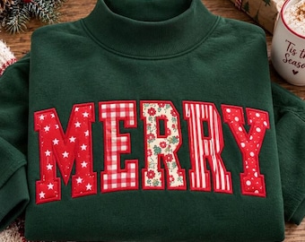 May include: A dark green mock neck sweatshirt featuring the word MERRY in large, block-style letters across the chest. Each letter has a unique pattern, including white stars, red and white gingham, floral print, red stripes, and white dots.