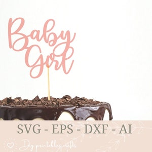 Puede incluir: Un adorno rosa para pastel con la frase "Baby Girl" sobre un pastel glaseado con chocolate. El pastel está cubierto con virutas de chocolate. La imagen también incluye el texto "SVG - EPS - DXF - AI" y "DIY printables crafts".