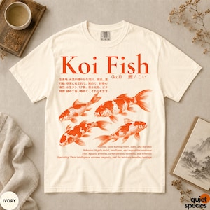 以下が含まれることがあります： アイボリーの半袖Tシャツで、4匹の鯉が描かれた大きなオレンジ色のグラフィックが特徴です。デザインには「Koi Fish」という文字、日本語の表記、そして鯉の生息地、行動、食性、特徴を説明する英語のテキストが含まれています。