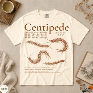 May include: An ivory short-sleeve t-shirt featuring a brown graphic print of three centipedes. The design includes the text Centipede, Japanese characters, and English descriptions detailing the habitat, behavior, diet, and anatomy of the insect.