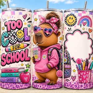 May include: A cylindrical tumbler featuring a capybara wearing a pink hoodie, heart-shaped sunglasses, and a floral headband. The design includes the text 'TOO COOL FOR SCHOOL', a stack of books, a pencil, a juice box, and a cup filled with pens.