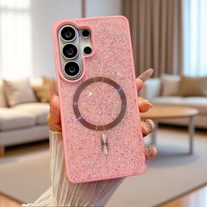 May include: A pink smartphone case covered in small, reflective, light-catching crystals. The case features a circular magnetic ring centered on the back and a rectangular camera cutout at the top left with multiple circular lens openings.