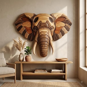 May include: A large wall-mounted elephant head sculpture crafted from segmented pieces of light, medium, and dark-toned wood. The artwork features intricate grain patterns, curved tusks, and a detailed trunk, creating a dimensional mosaic effect.