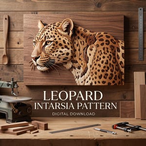 Puede incluir: Una pieza de arte mural de marquetería de madera que muestra un leopardo con manchas marrones y negras. El texto LEOPARD INTARSIA PATTERN DIGITAL DOWNLOAD aparece debajo de la obra. La escena incluye una sierra de calar, restos de madera y una regla.
