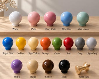 May include: A collection of spherical cabinet knobs in various solid colours including white, pink, dusty pink, sky blue, mint green, royal blue, yellow, light yellow, orange, green, red, grey, light grey, purple, beige, coffee, and black, with a gold base.