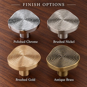 Puede incluir: Cuatro pomos de armario etiquetados FINISH OPTIONS. Arriba a la izquierda cromo pulido, arriba a la derecha níquel cepillado, abajo a la izquierda oro cepillado y abajo a la derecha latón antiguo. Cada pomo tiene una textura circular en espiral.