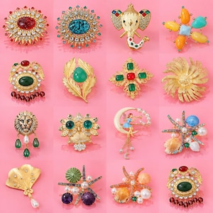May include: A collection of sixteen assorted decorative brooches featuring various designs including an elephant, a lion, an owl, floral motifs, sea creatures, and abstract shapes, crafted with gold-tone metal, colorful gemstones, and faux pearls.