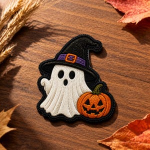 May include: An embroidered patch featuring a white ghost wearing a black witch hat with a purple band and orange buckle, positioned next to an orange jack-o'-lantern with a green stem, all outlined in black thread on a dark fabric backing.