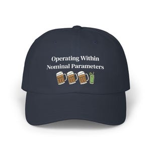 May include: A navy blue baseball cap featuring the white text Operating Within Nominal Parameters above a graphic of three beer mugs and one green cocktail glass with a straw, centered on the front panel of the structured six-panel hat.
