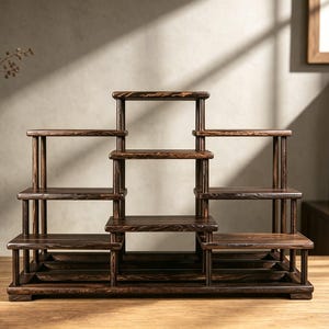 May include: A multi-tiered dark brown wooden display stand featuring a stepped design with various horizontal shelves supported by vertical pillars. The structure has a symmetrical arrangement with a central elevated section and lower side platforms.