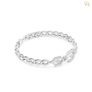 May include: A silver-toned bangle bracelet featuring a repeating openwork link pattern. The design includes two prominent hexagonal-shaped links encrusted with small, clear, sparkling stones, creating a continuous circular structure.
