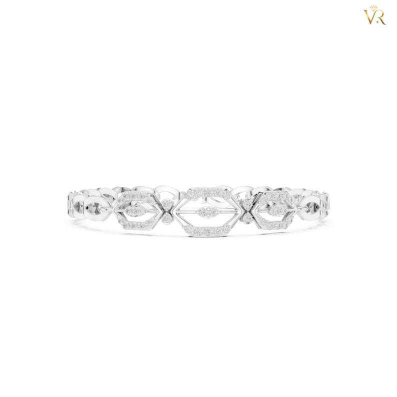 May include: A silver-toned bracelet featuring a series of interconnected geometric links. Each link is shaped like an elongated hexagon with a central horizontal bar, and the entire surface is encrusted with small, clear, sparkling stones.