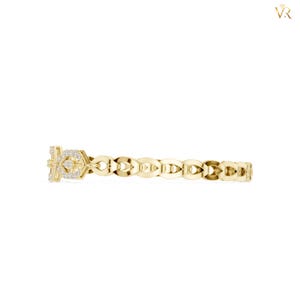 May include: A yellow gold ring featuring a repeating openwork link pattern along the band. The focal point is a rectangular section adorned with small, clear, sparkling stones set into the metal, creating a textured and reflective surface.