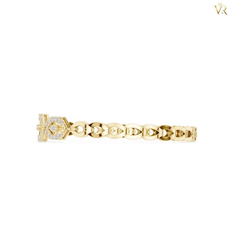 May include: A yellow gold ring featuring a repeating openwork link pattern along the band. The focal point is a rectangular section adorned with small, clear, sparkling stones set into the metal, creating a textured and reflective surface.