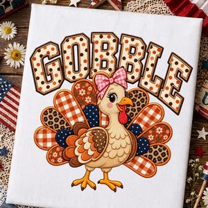 May include: A white canvas featuring a cartoon turkey with a pink bow on its head, surrounded by colorful patterned feathers in plaid, floral, and leopard print. Above the turkey, the word GOBBLE is written in large, brown, polka-dotted letters.
