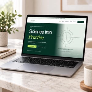 Könnte beinhalten: Ein silberner Laptop, der eine Website mit dem Titel Life Science und dem Text Science into Practice anzeigt. Der Bildschirm hat einen dunkelgrünen Hintergrund, eine kreisförmige Zielgrafik und Schaltflächen mit der Aufschrift Explore our solutions und Request a quotation.