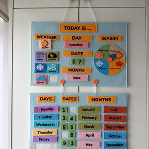 May include: A light blue felt wall calendar with orange headers and colorful labels. The top section displays weather, day, date, month, and season with a circular chart. The bottom section features columns for days, dates, and months with removable pieces.