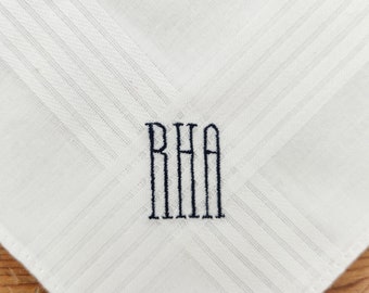 May include: White linen pocket square with the initials "RHA" embroidered in black thread.