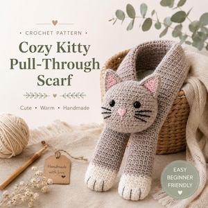 May include: A crochet pattern for a gray kitty pull-through scarf featuring a cat head with pink ears, black eyes, and whiskers. The scarf has white paws at the ends. Text includes "Crochet Pattern," "Cozy Kitty Pull-Through Scarf," and "Easy Beginner Friendly."