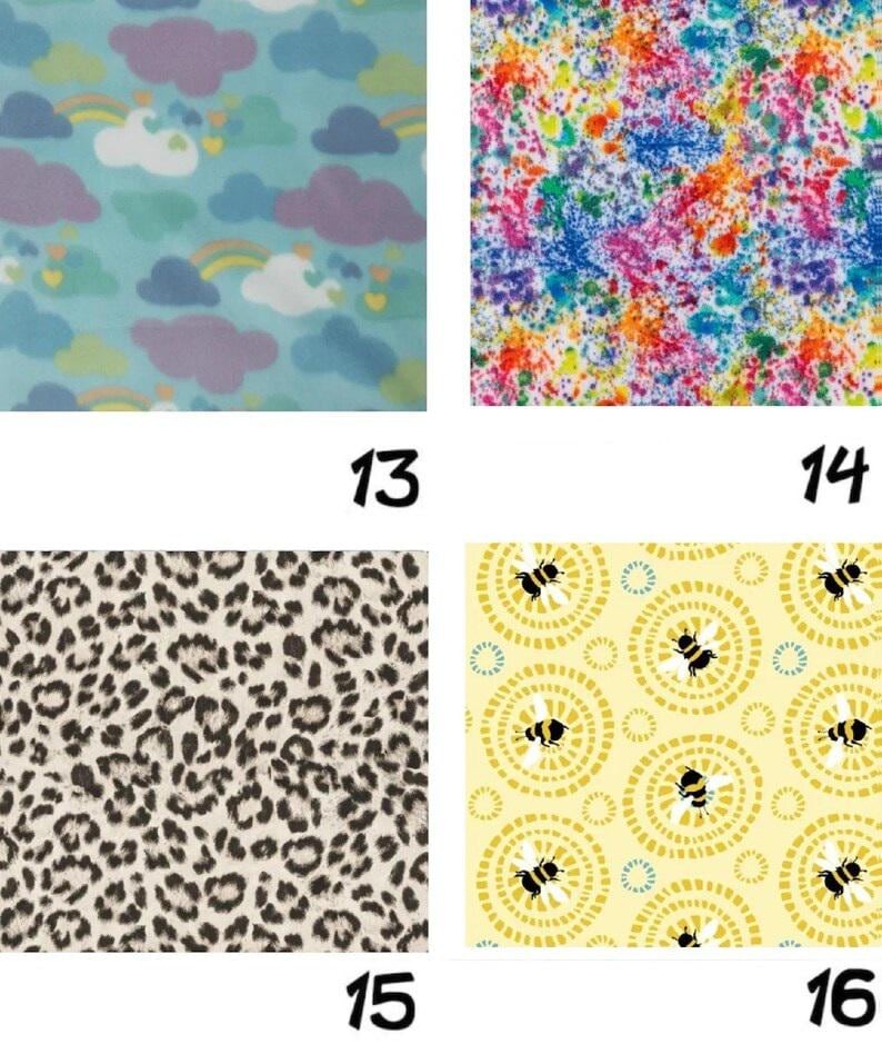 May include: Four fabric swatches with different patterns. Top left: blue background with clouds, rainbows, and hearts. Top right: colorful paint splatter design. Bottom left: leopard print. Bottom right: yellow background with bees.