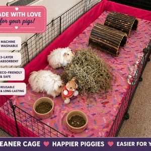 May include: A pink guinea pig cage liner with a colorful sprinkle pattern, featuring two white guinea pigs, two wooden log tunnels, a pile of hay, two ceramic bowls with food, and a small plush toy. Text includes MADE WITH LOVE for your pigs!