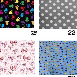 May include: Four fabric swatches labeled 21 through 24. Swatch 21 features colorful paw prints on black. Swatch 22 shows white polka dots on gray. Swatch 23 displays pink bows on a light background. Swatch 24 has multicolored dots on blue.