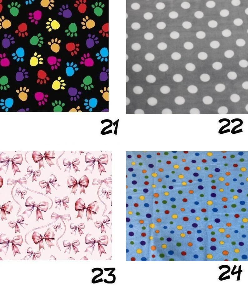 May include: Four fabric swatches labeled 21 through 24. Swatch 21 features colorful paw prints on black. Swatch 22 shows white polka dots on gray. Swatch 23 displays pink bows on a light background. Swatch 24 has multicolored dots on blue.