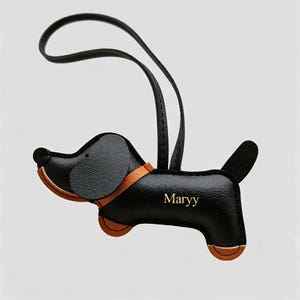 May include: A black leather dog-shaped keychain with a tan collar and accents on the paws and snout. The name Maryy is embossed in gold lettering on the side of the body. A black leather loop is attached to the top for hanging or attachment.