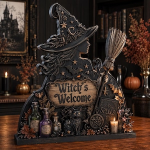 Könnte beinhalten: Ein dekoratives Tischschild mit der Silhouette einer Hexe, die einen Hut mit Sternen und Monden trägt und einen Besen hält. Das Schild zeigt den Text "Witch's Welcome" über einer schwarzen Katze, einem "Spells"-Buch, einem Pentagramm und Fläschchen.