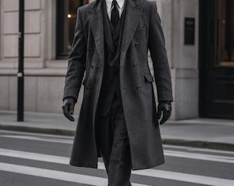 May include: A charcoal gray double-breasted overcoat worn over a dark suit, white collared shirt, and black tie. The ensemble includes black leather gloves and black dress shoes. The text "W wearivaa TIMELESS STYLE. MODERN CONFIDENCE." appears in the corner.