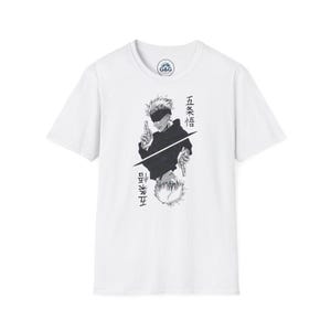 Könnte beinhalten: Ein weißes T-Shirt mit kurzen Ärmeln und einer schwarz-weißen Grafik eines Anime-Charakters mit stacheligen Haaren und Augenbinde. Das Design zeigt einen gespiegelten Effekt mit japanischen Schriftzeichen und einem G&G-Logo am Innenkragen.