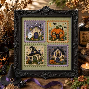 May include: A framed cross-stitch embroidery featuring four distinct square panels on a sage green background. The panels depict a mushroom house with a ghost, a pumpkin house with a crescent moon, a witch hat house, and a house with a black cat.
