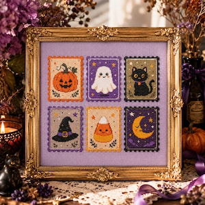 May include: A framed cross-stitch embroidery on light purple fabric featuring six rectangular postage stamp designs. The motifs include an orange pumpkin, a white ghost, a black cat, a black witch hat, a candy corn, and a yellow crescent moon.