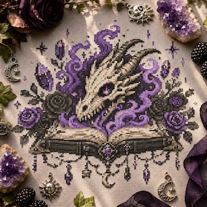 May include: A cross-stitch embroidery on light fabric featuring a central dragon skull emerging from an open book, surrounded by purple smoke, dark roses, and crystals. The design includes hanging charms, stars, and crescent moon motifs in shades of purple, black, and cream.